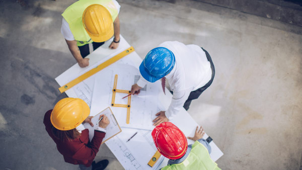 Zdjęcie mężczyzny rozpylającego izolację celulozową na podłogę strychu