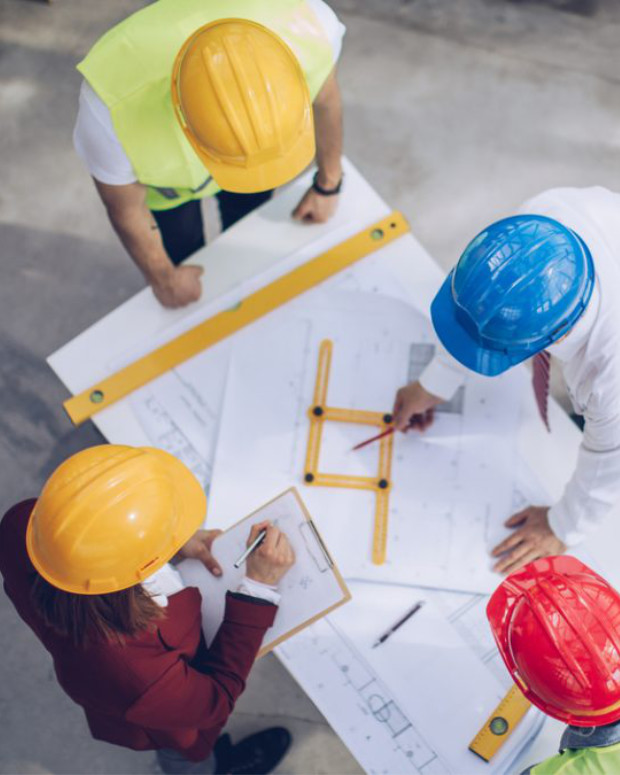 Zdjęcie mężczyzny rozpylającego izolację celulozową na podłogę strychu